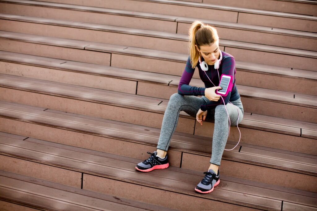 Young woman resting after jogging on stairs outdoor